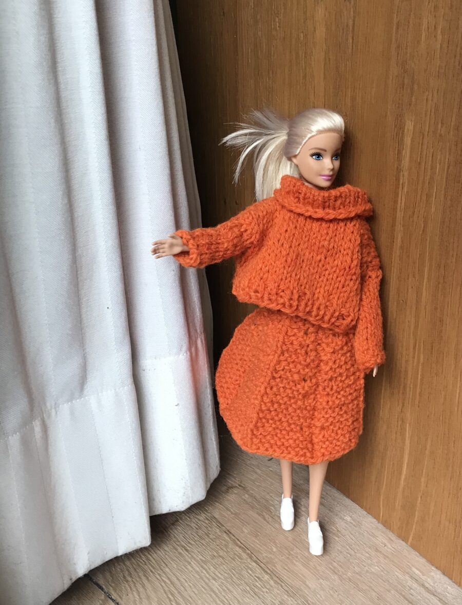 Barbie Pullover stricken mit Rollkragen in leuchtendem Orange. Dazu passend einen Rock mit breit gestricktem Sonnenplissee. Kostenlose Strickanleitung